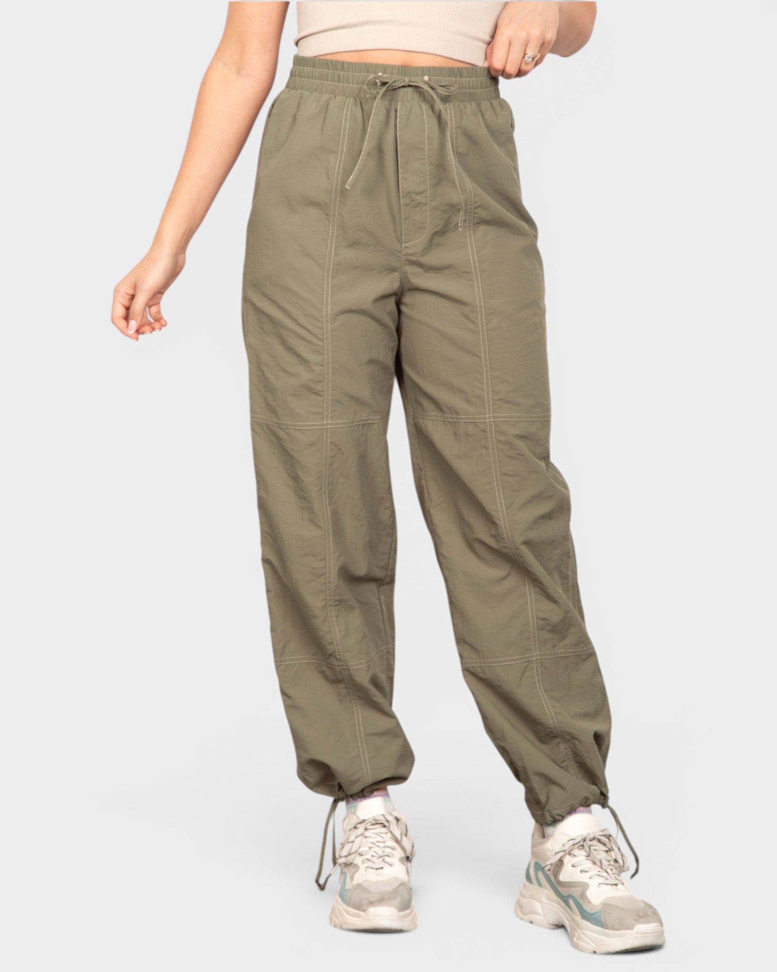 Person wearing olive green pants on a white background