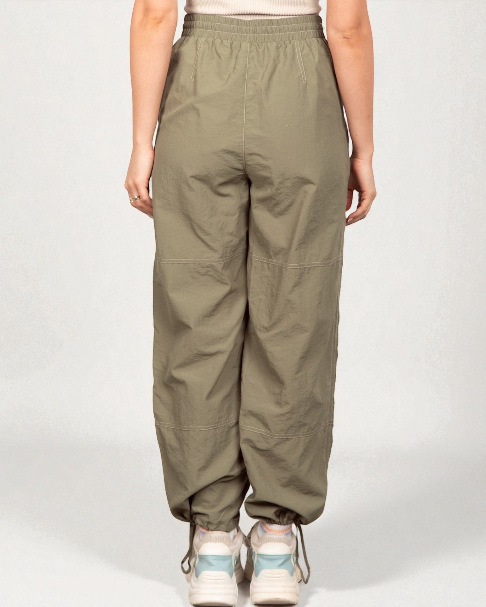 Person wearing olive green pants on a white background