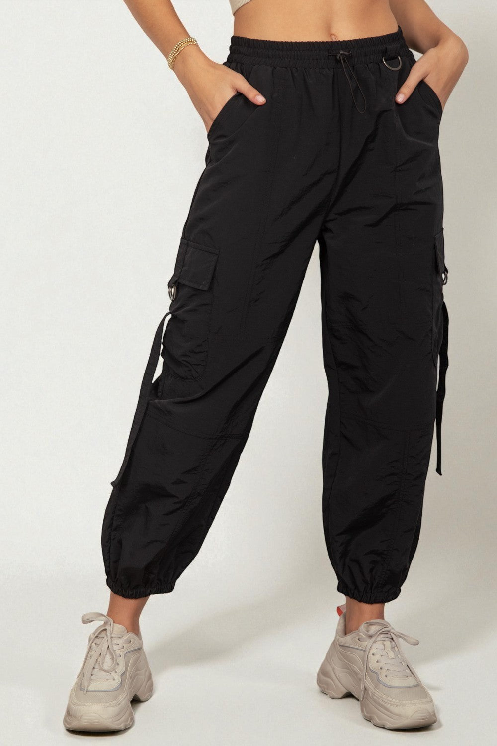 Black cargo pants worn by a person on a white background