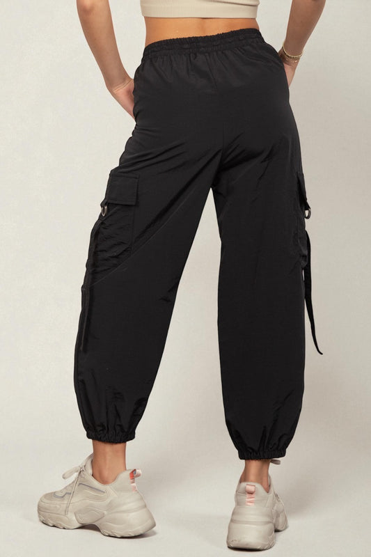 Person wearing black cargo jogger pants on a plain background