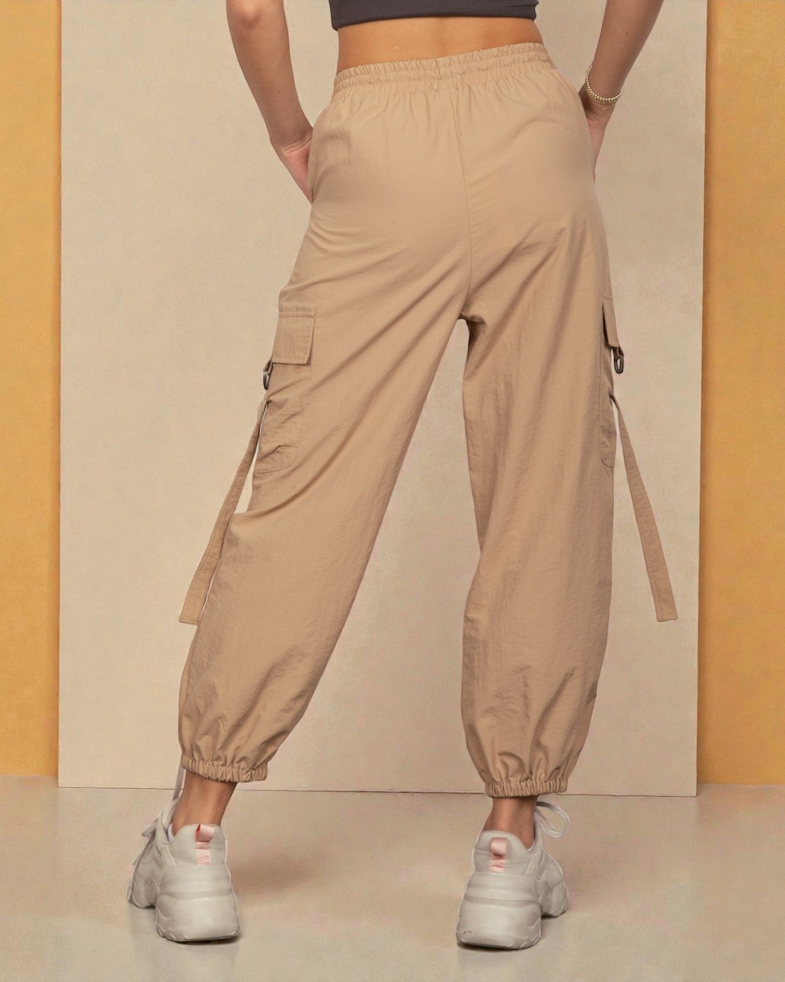 Beige cargo pants worn by a person on a neutral background