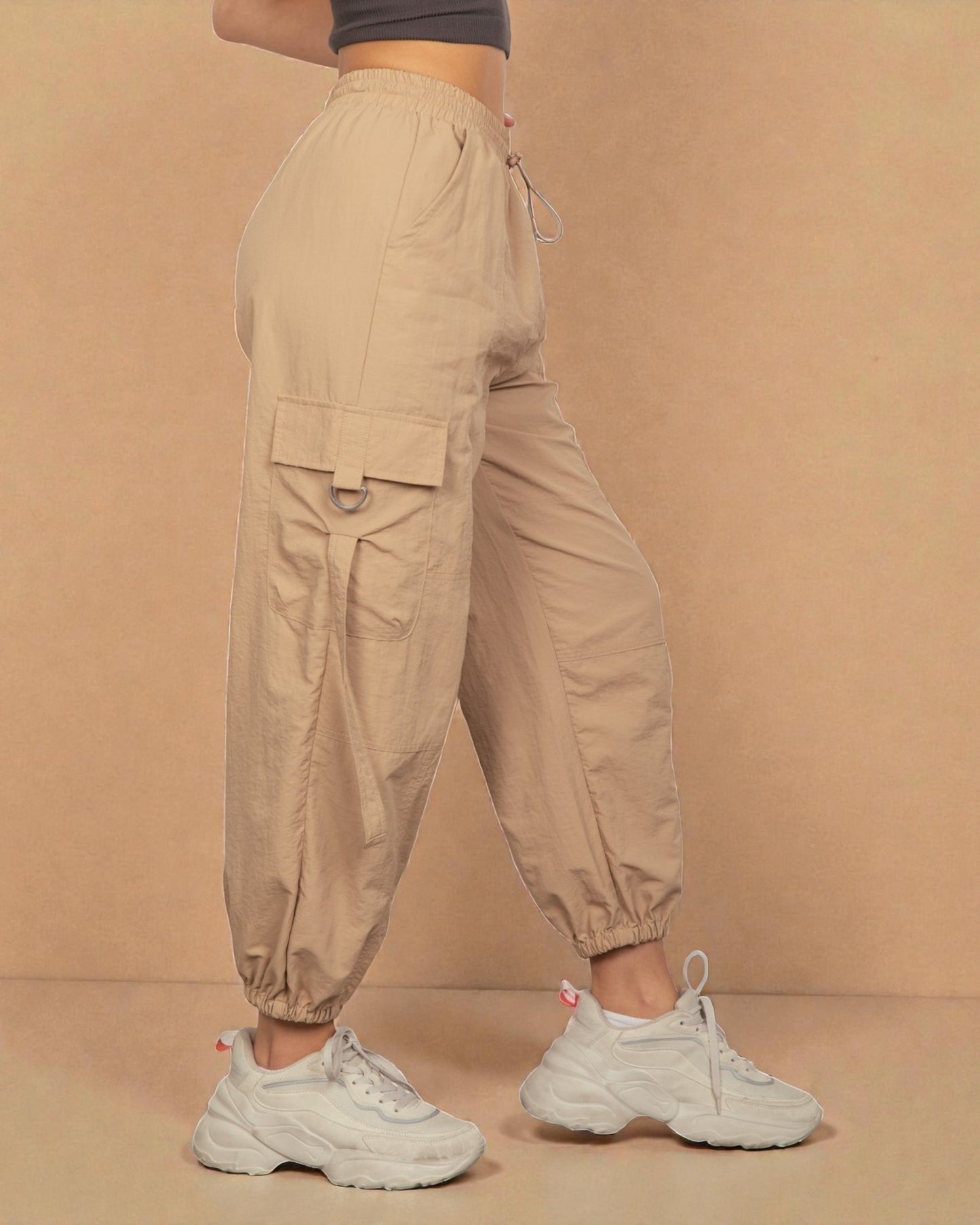 Beige cargo pants worn by a person on a beige background