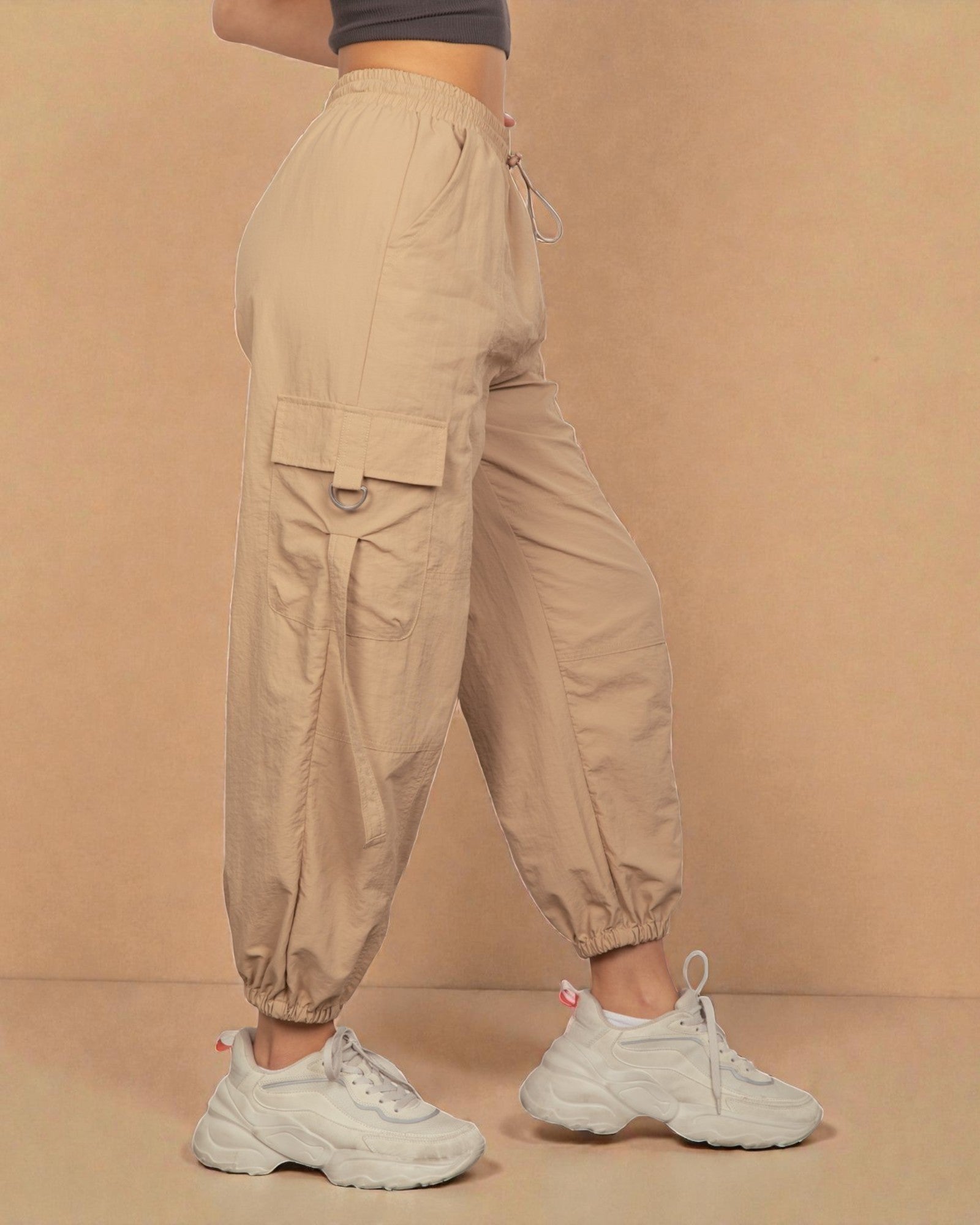 Beige cargo pants worn by a person on a beige background