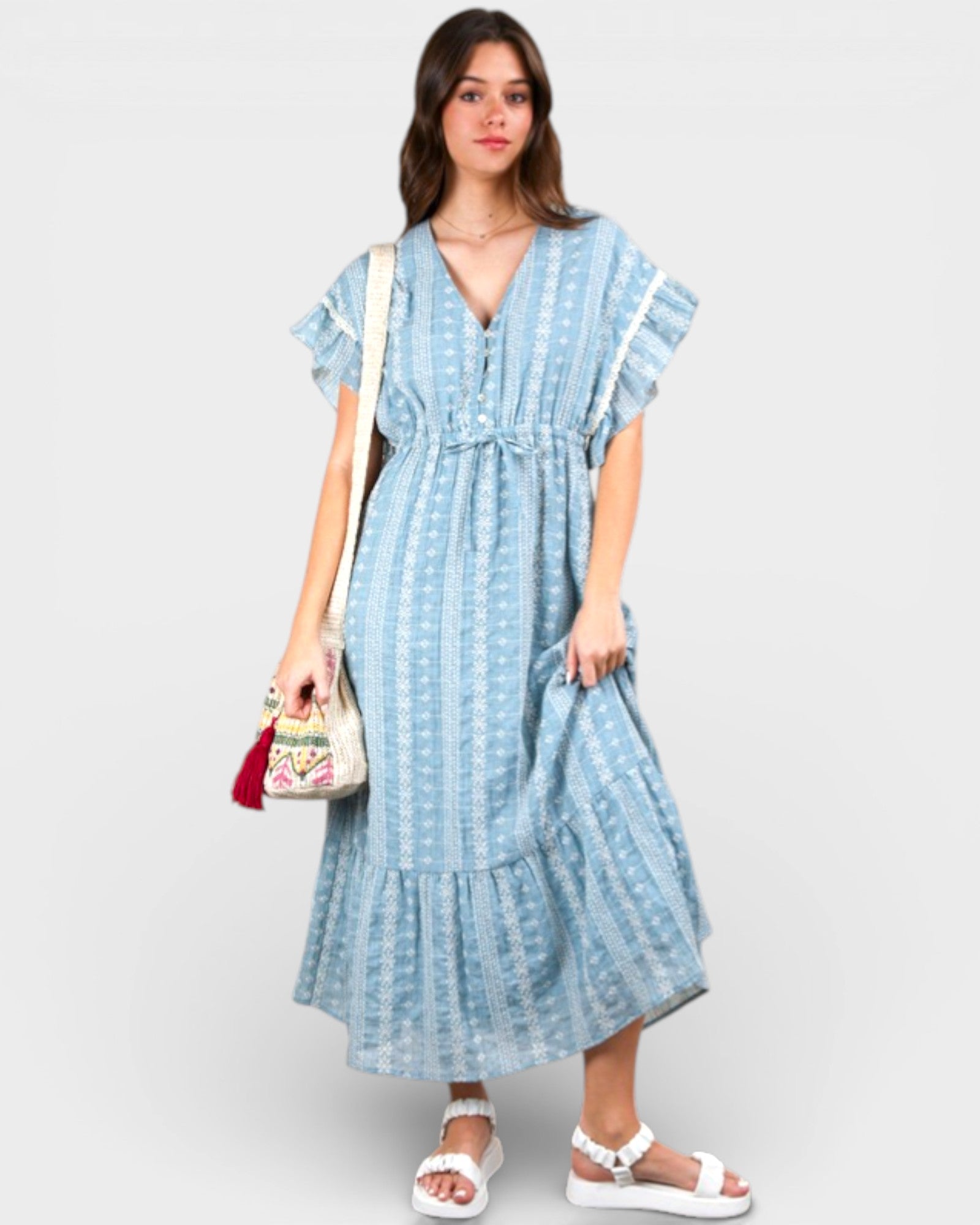 Woman wearing a blue patterned dress with a white background