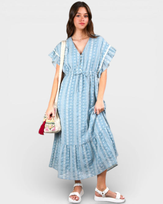 Woman wearing a blue patterned dress with a white background