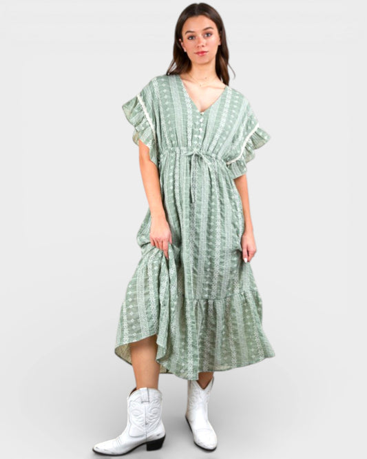 Woman wearing a green patterned dress on a white background