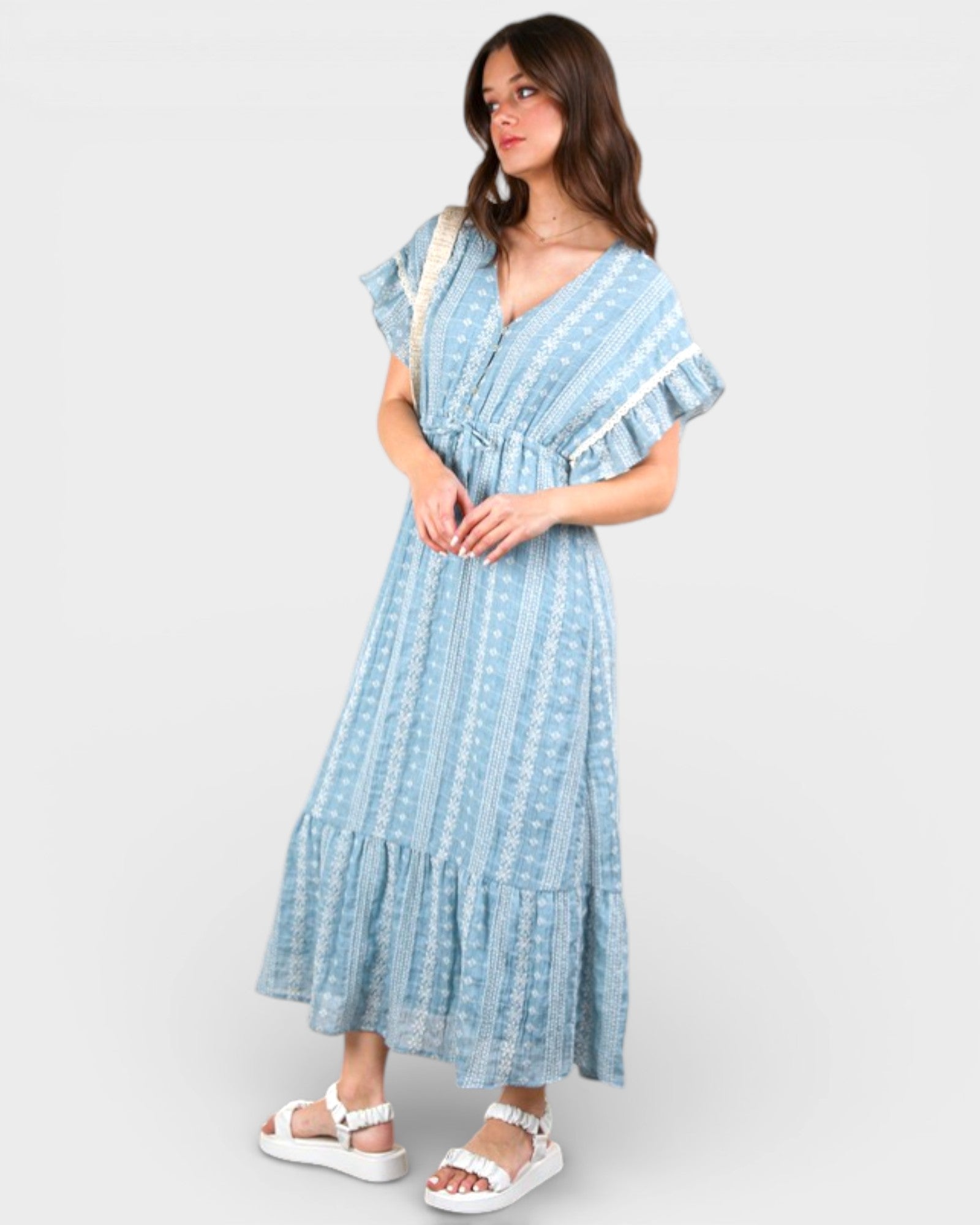 Woman wearing a blue and white patterned dress on a white background