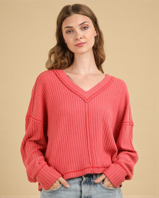 Woman wearing a pink sweater against a beige background