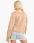 A woman shown from the back wearing a light beige ribbed knit sweater and light blue denim shorts against a plain white background.
