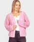Woman wearing a pink knitted cardigan on a plain background