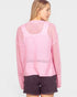 Woman wearing a pink knitted sweater and dark shorts on a white background