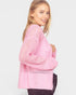 Woman wearing a pink sweater on a plain background
