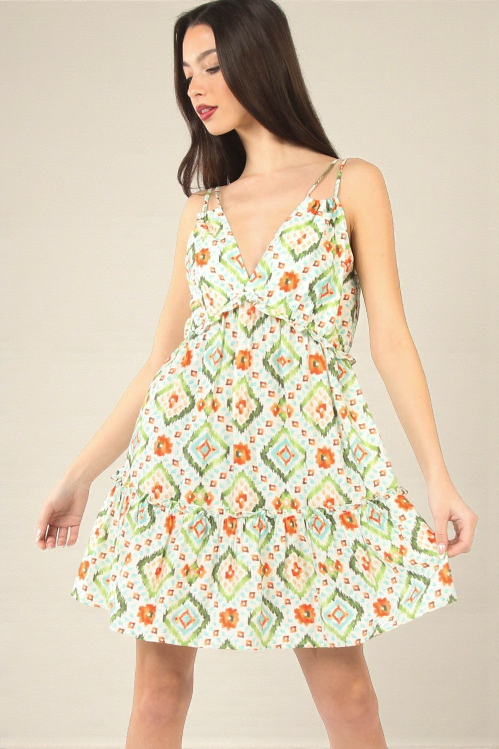 Woman wearing a patterned dress on a plain background