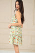 Woman wearing a floral dress against a beige wall