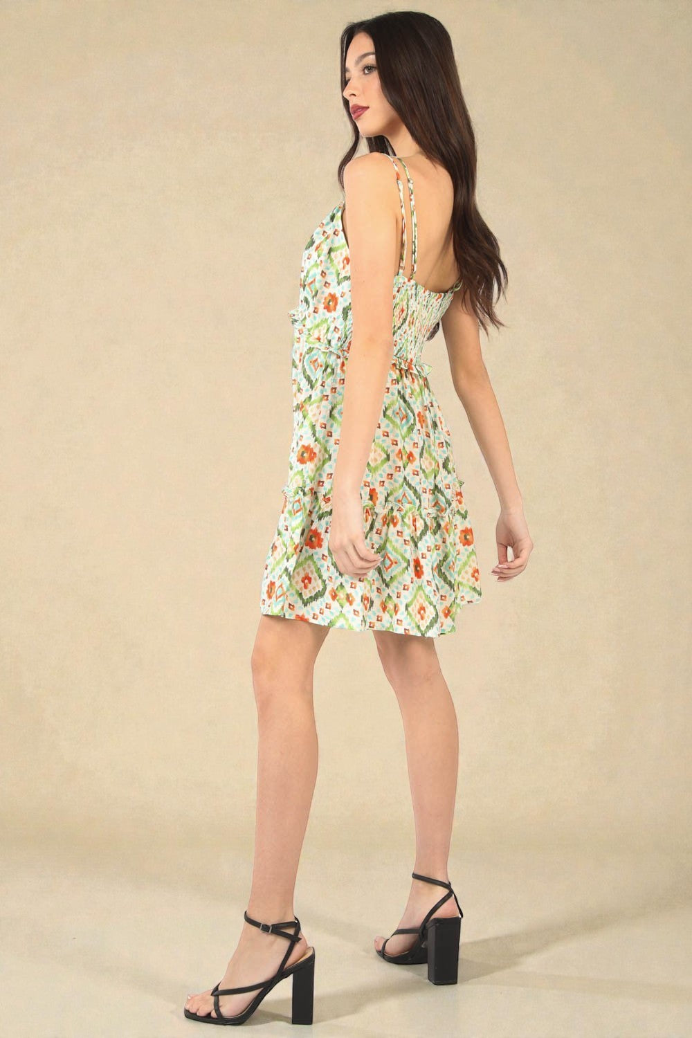 Woman wearing a floral dress against a beige background