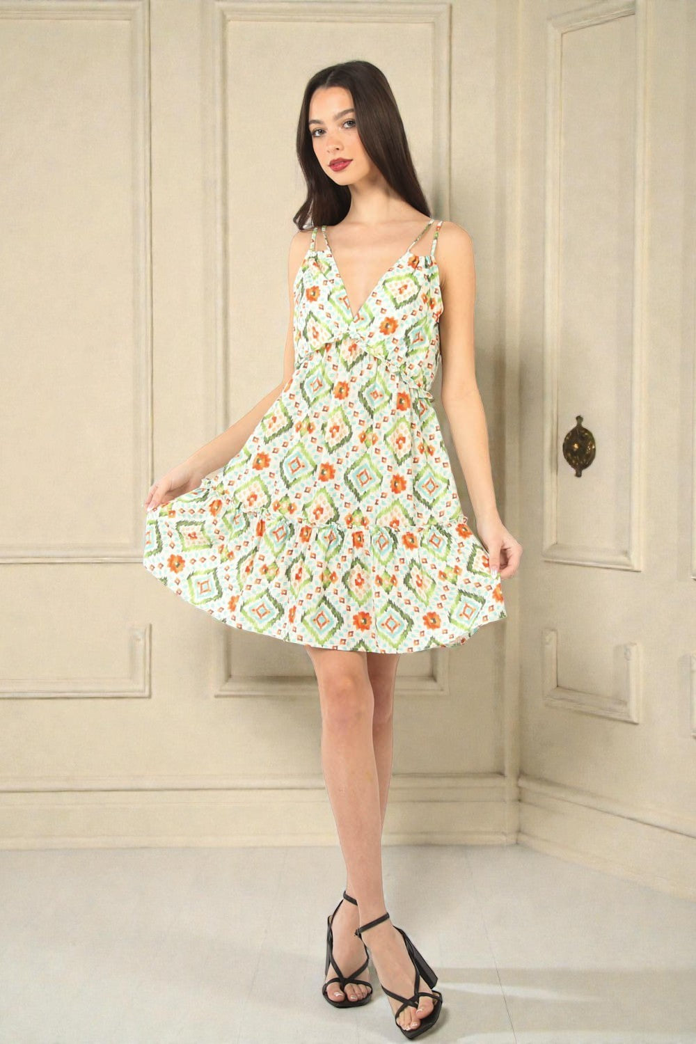 Woman wearing a floral dress in a room with beige walls.