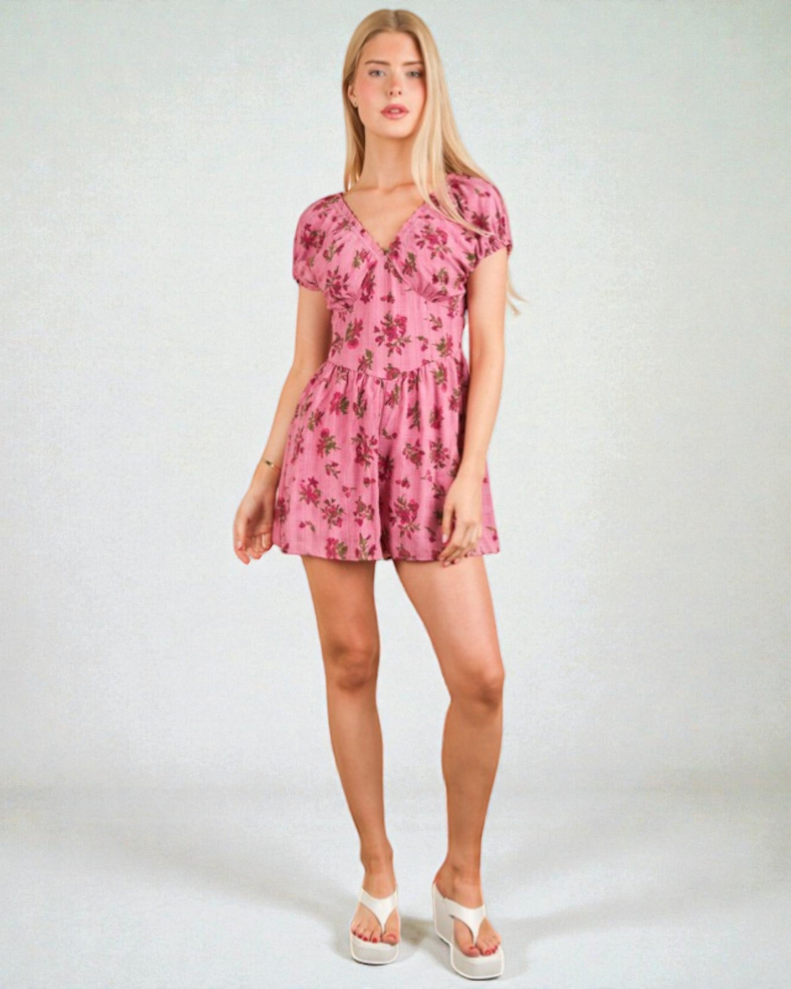Woman wearing a pink floral dress on a white background
