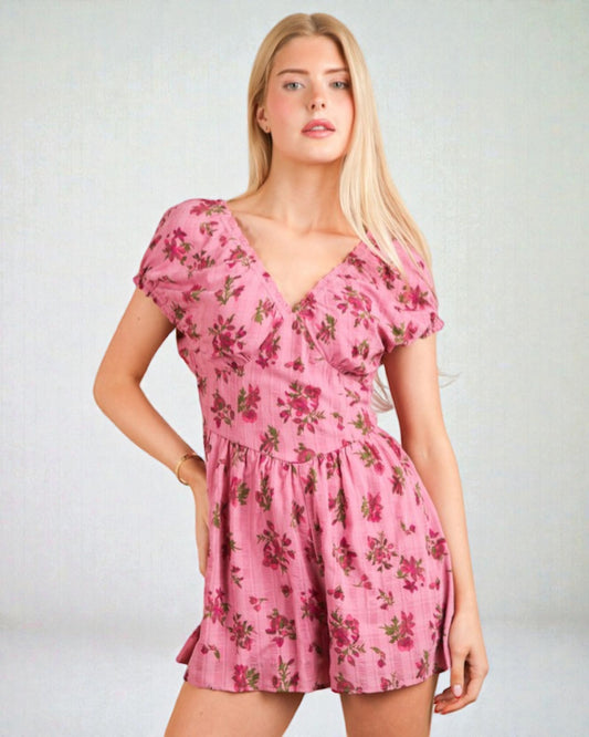 Woman wearing a pink floral dress against a plain background