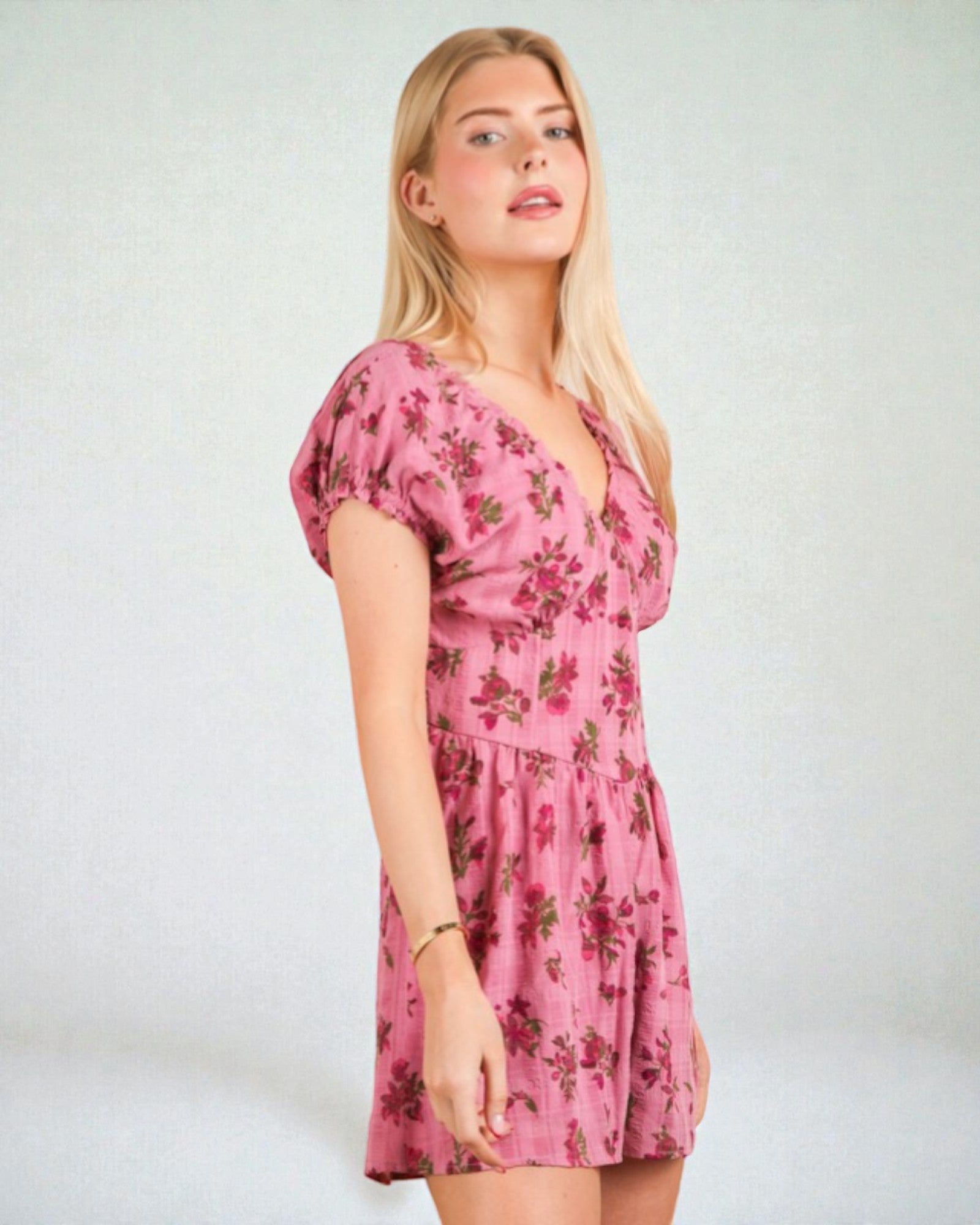 Woman wearing a pink floral dress against a white background