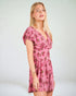 Woman wearing a pink floral dress against a white background