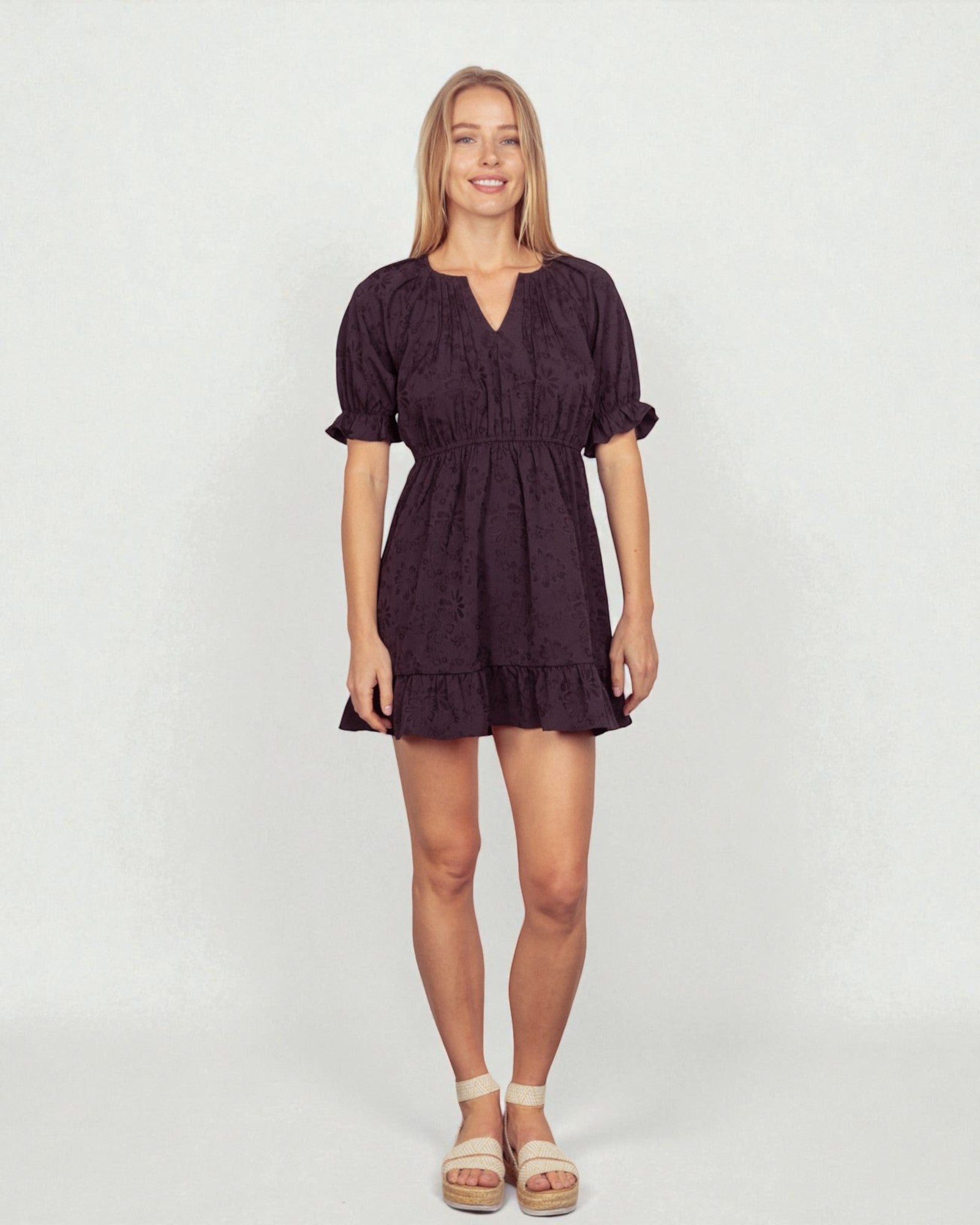 Woman wearing a dark purple dress on a white background