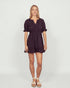 Woman wearing a dark purple dress on a white background