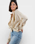 Woman wearing a beige checkered shirt and blue jeans on a white background