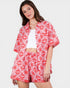 Woman wearing a red and white patterned outfit on a plain background