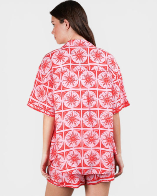 Woman wearing a red and white patterned shirt on a plain background