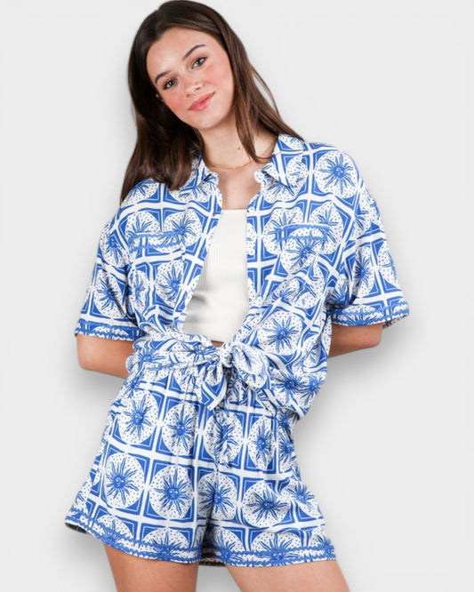 Woman wearing a blue and white patterned outfit on a plain background