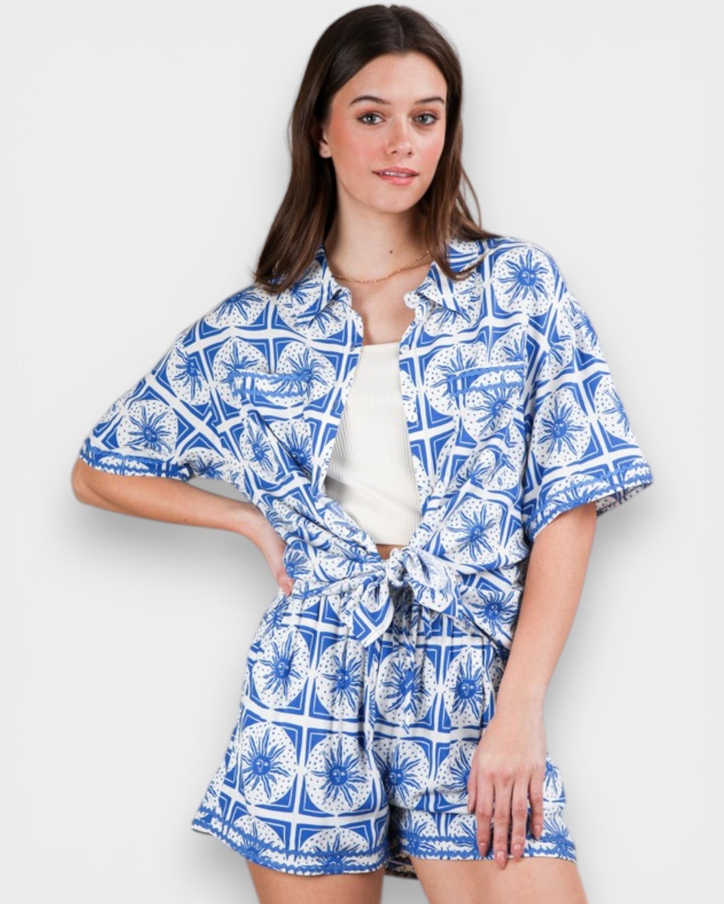 Woman wearing a blue and white patterned outfit on a plain background