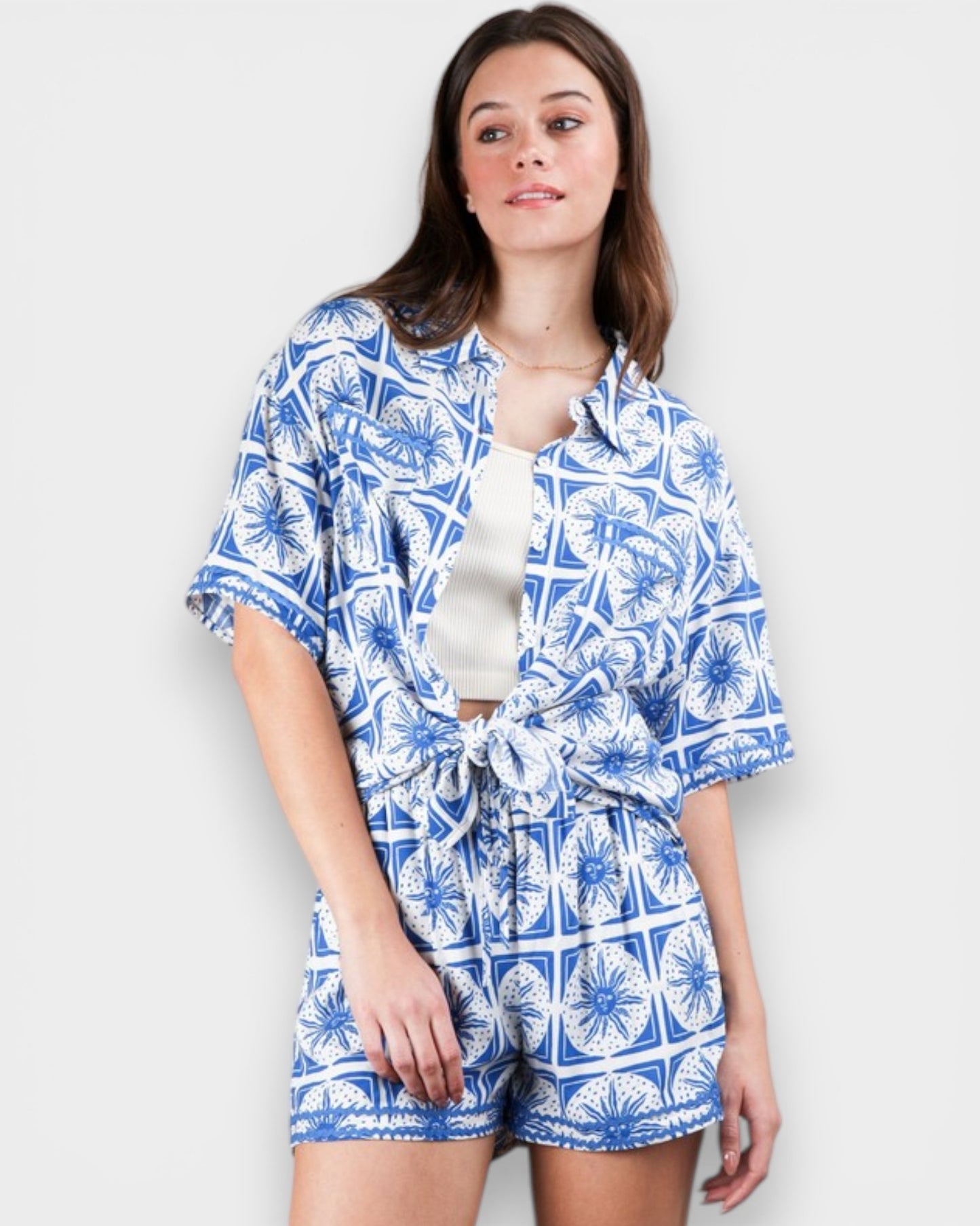Woman wearing a blue and white patterned outfit on a plain background