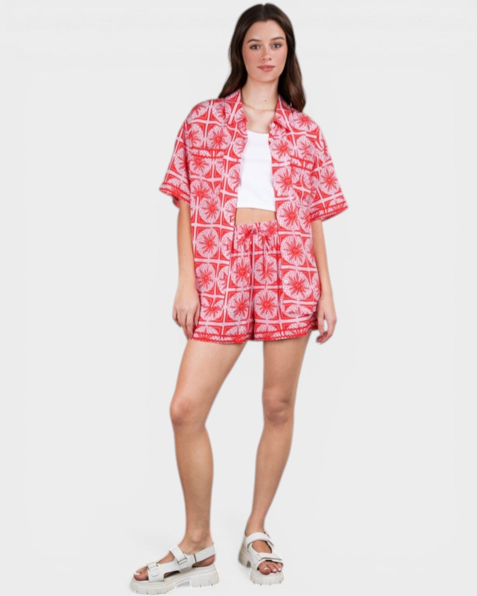 Woman wearing a red and white patterned outfit on a white background