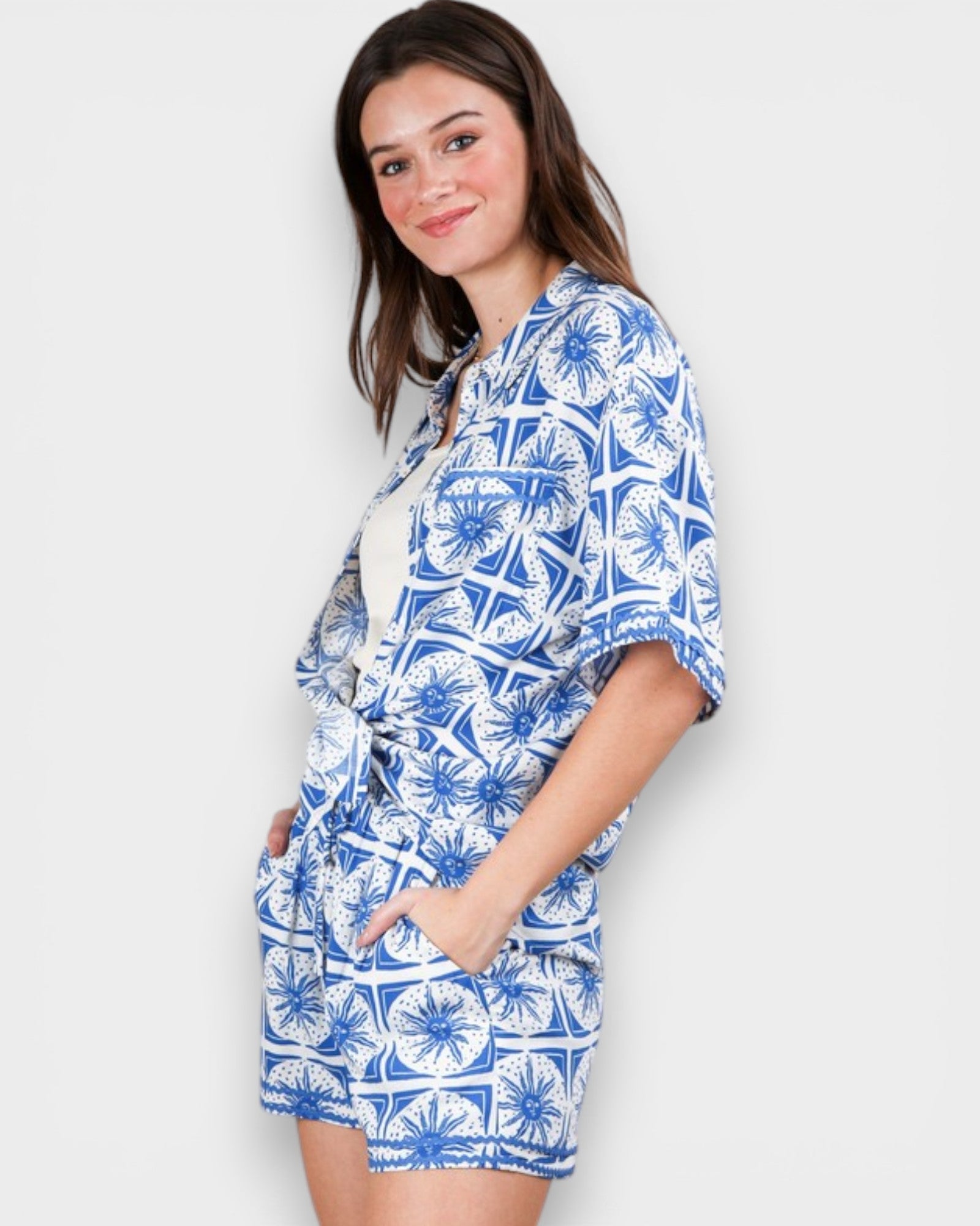 Woman wearing a blue and white patterned outfit on a plain background
