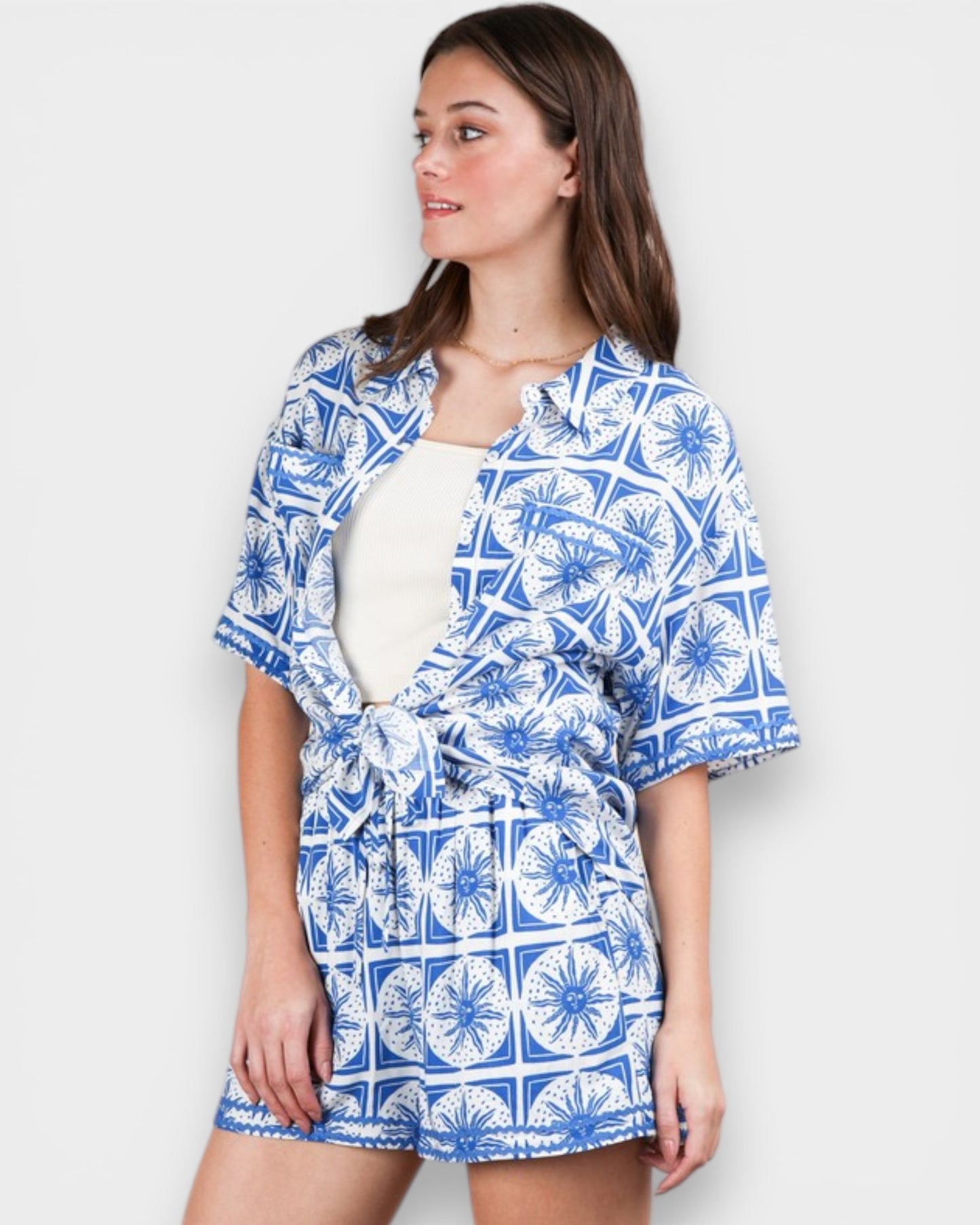 Woman wearing a blue and white patterned outfit on a plain background