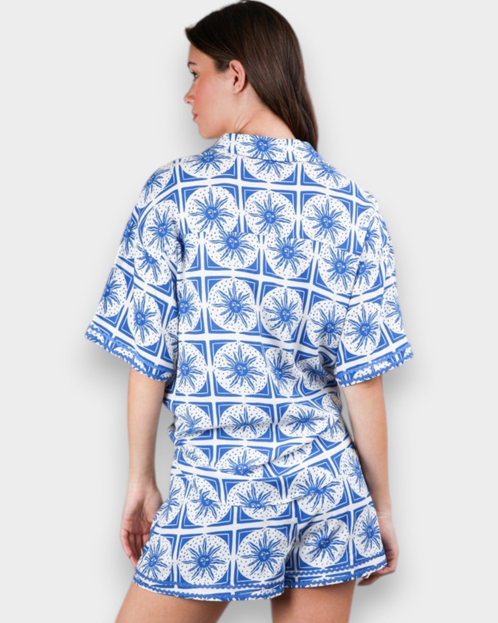 Woman wearing a blue and white patterned dress against a plain background