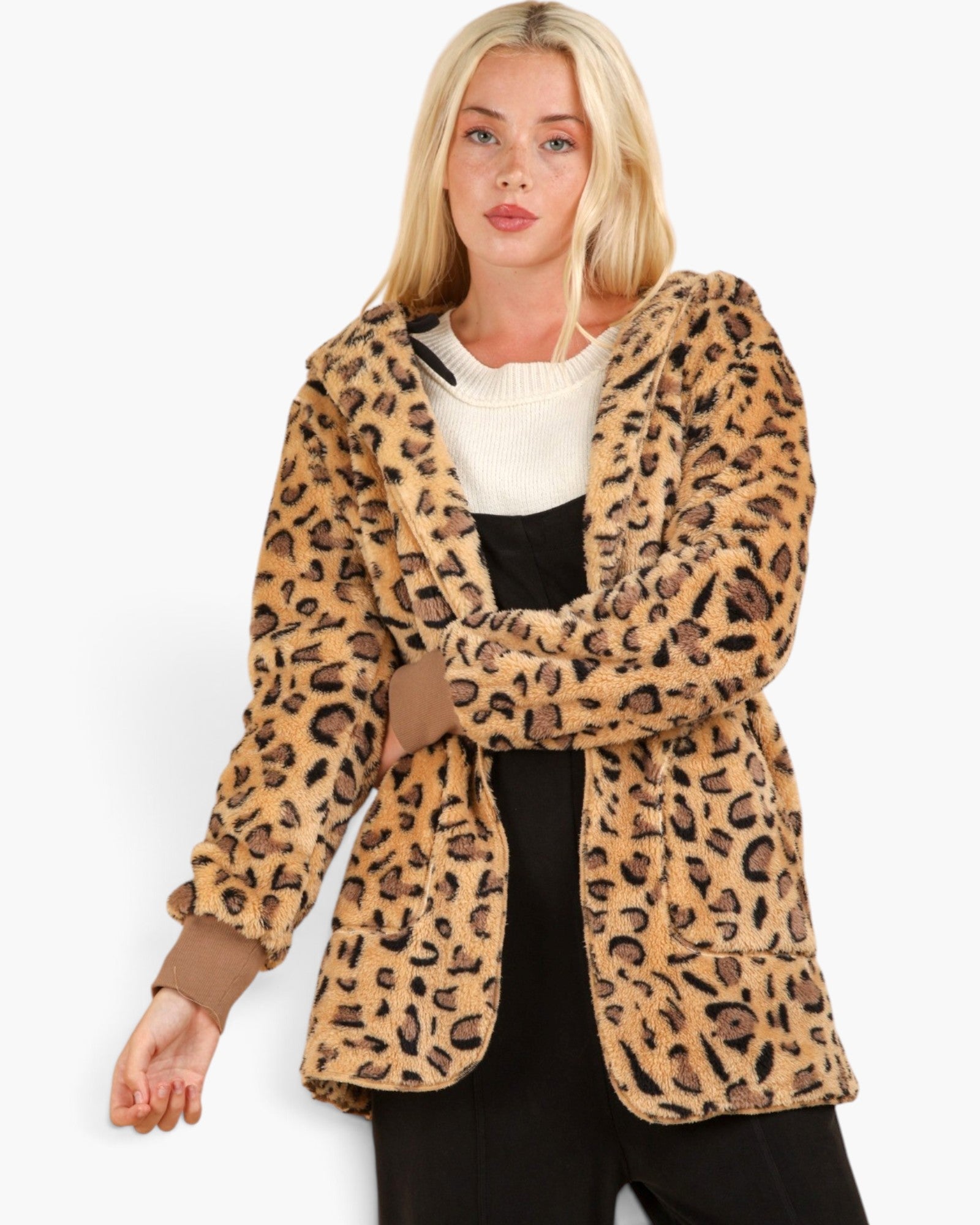 A blonde woman wearing a plush leopard-print hooded jacket over a white sweater and black top, photographed against a clean white studio background.