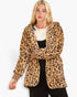 A blonde woman wearing a plush leopard-print hooded jacket over a white sweater and black top, photographed against a clean white studio background.