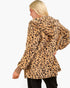 A woman shown from the back wearing a plush leopard-print hooded jacket in tan and brown tones, paired with black pants, against a plain white studio background.