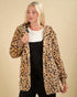 Woman wearing a leopard print coat against a beige background