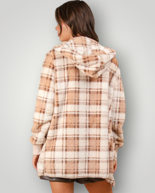 Person wearing a plaid hoodie against a plain background