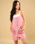 Woman wearing a pink romper with a beige background