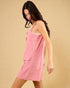 Woman wearing a pink dress against a beige background