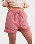 Pink shorts with lace trim worn by a person on a white background