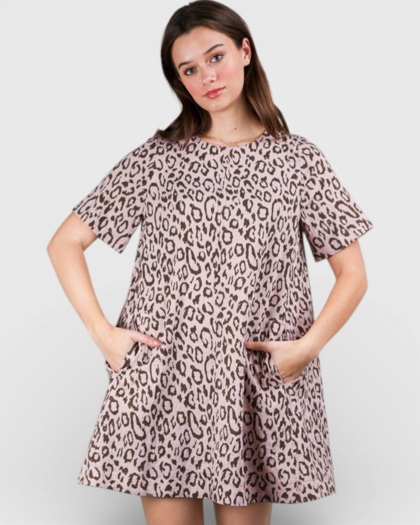 Woman wearing a leopard print dress on a plain background