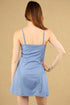 Woman wearing a blue dress against a beige background