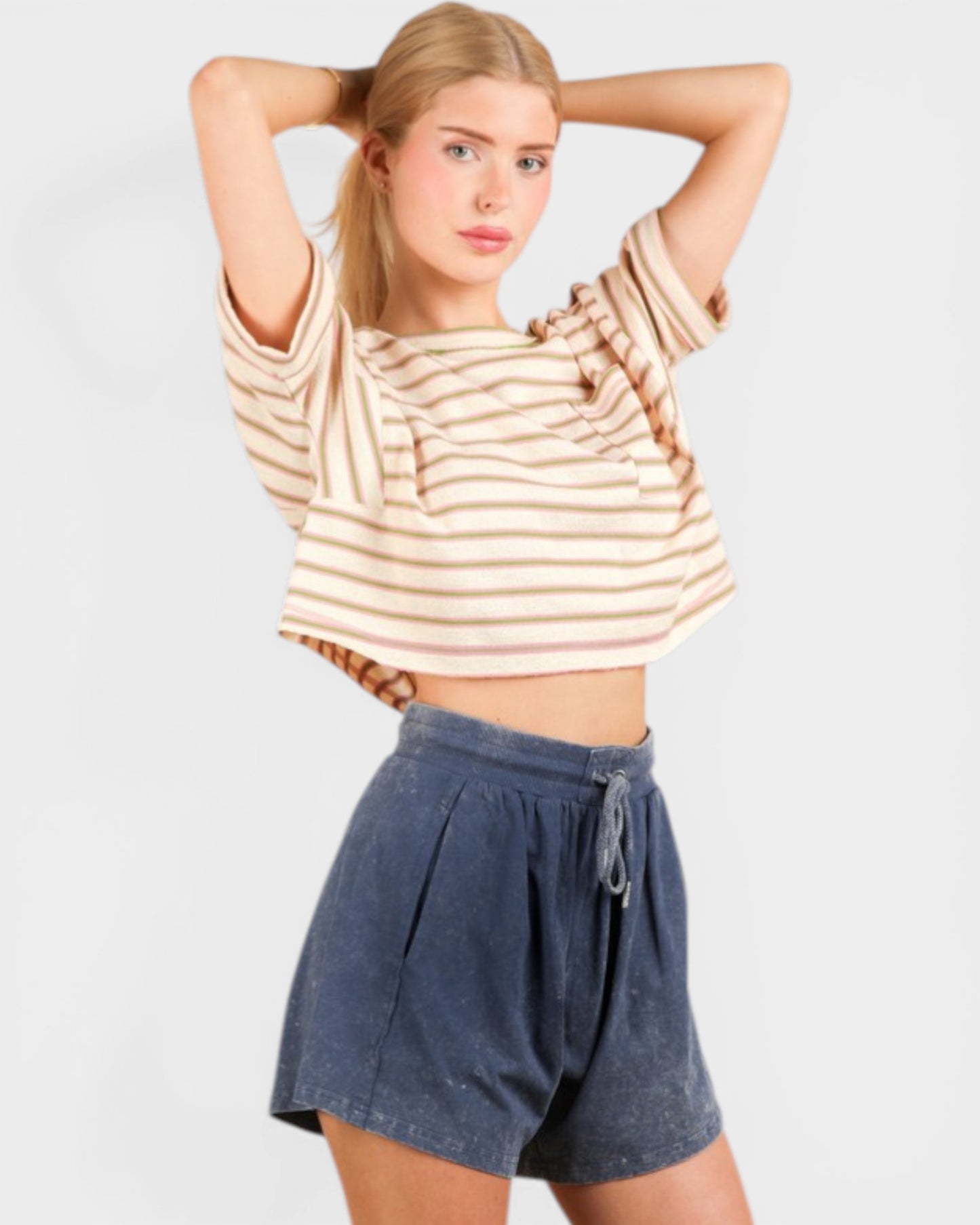 Woman wearing a striped top and denim shorts on a white background