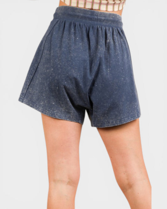 Blue shorts worn by a person on a white background