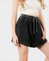 Person wearing black shorts with a white background