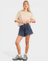 Woman wearing a striped shirt and denim shorts on a white background